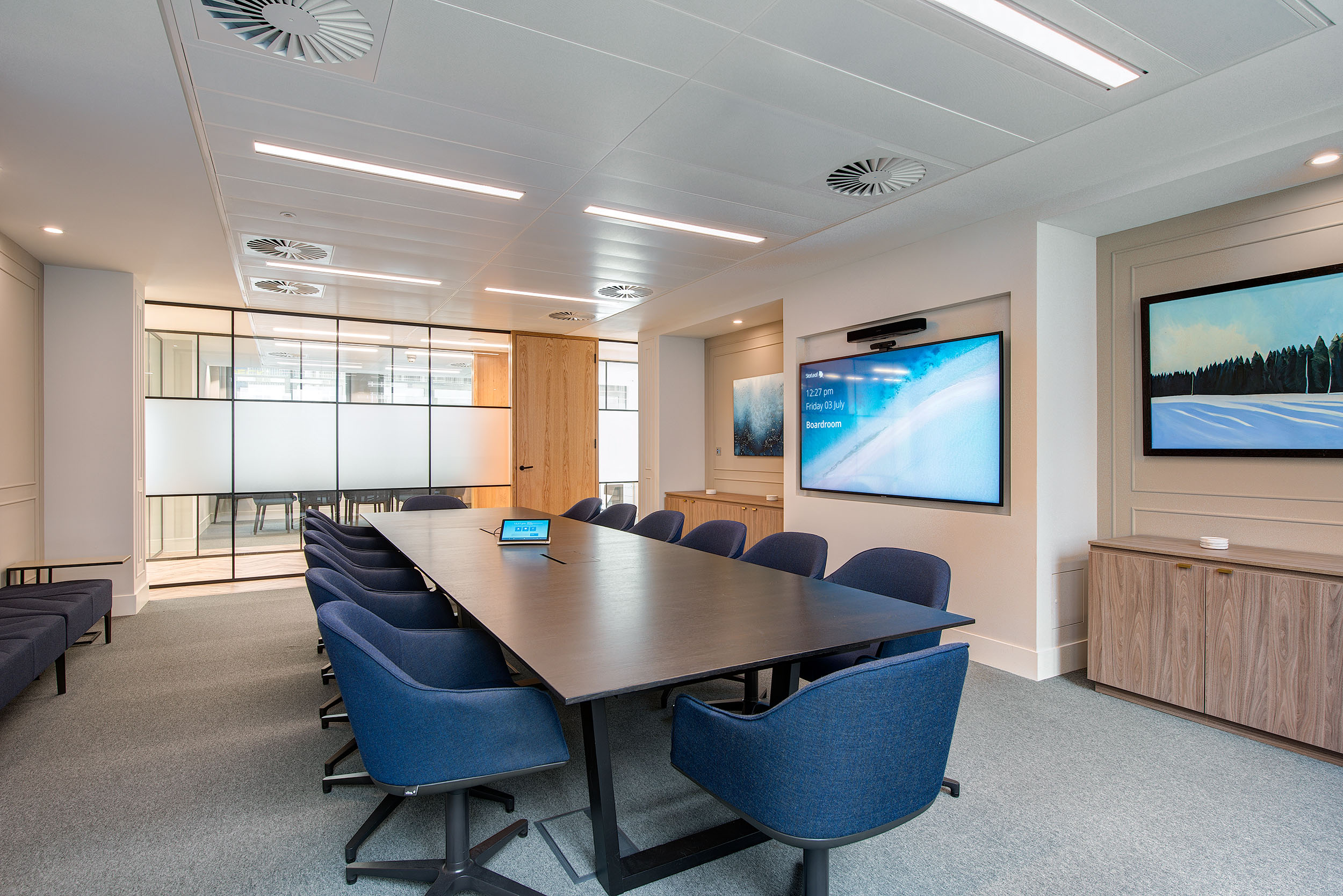 Modern meeting room at Guinness Asset Management designed by Modus Workspace, equipped with a large table, comfortable chairs, and advanced AV equipment for professional meetings.