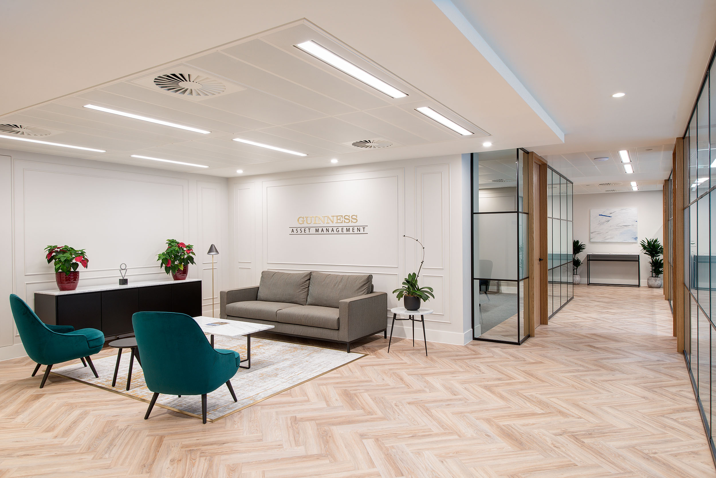 Entrance area of Guinness Asset Management's office, designed by Modus Workspace, featuring stylish seating and modern finishes for a professional and inviting look.