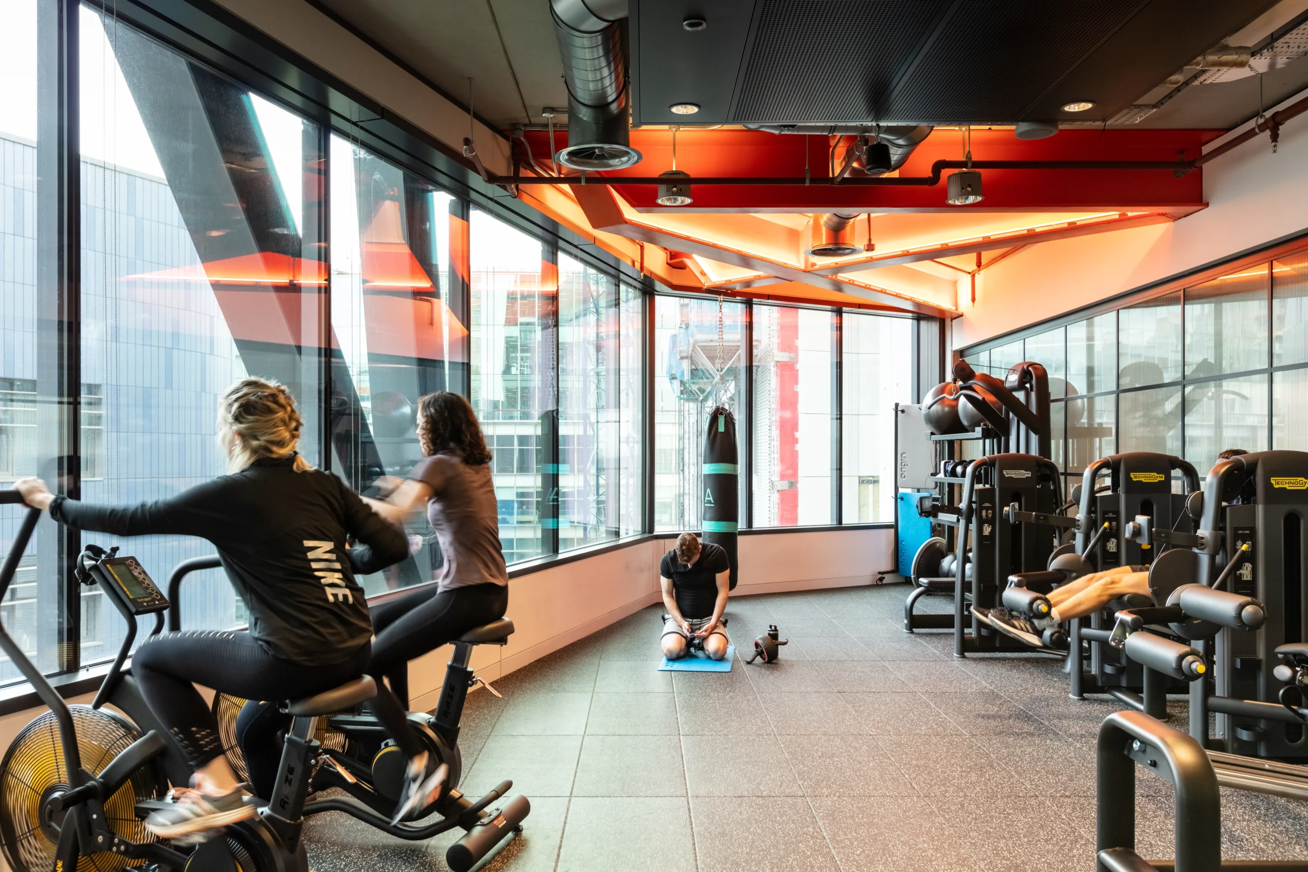 Alpha FX employees using their gym facility with the company's focus on workplace transformation and employee wellness through dedicated fitness spaces.