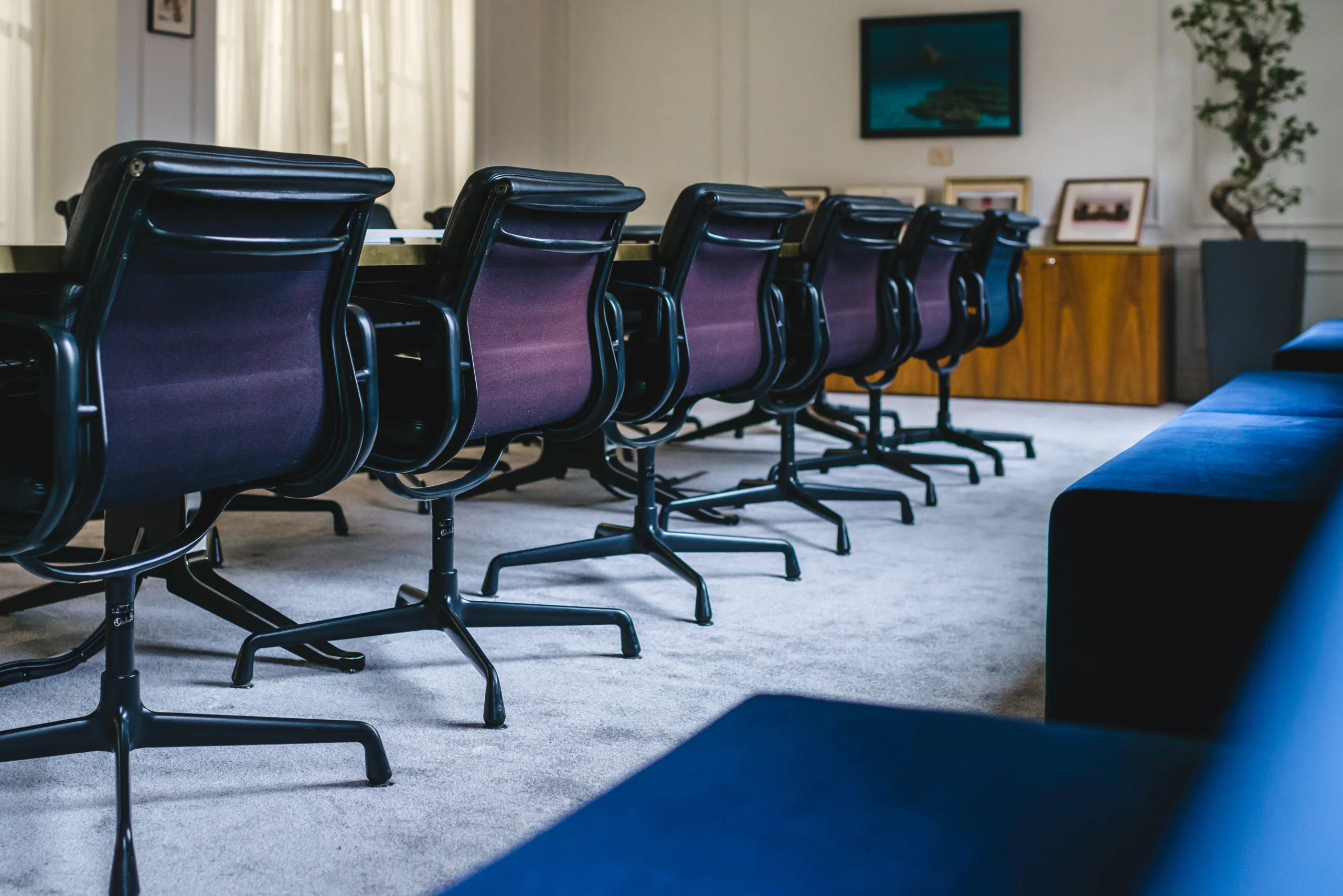 Close-up view of purple office chairs lined up in a conference room, showcasing their sleek design.