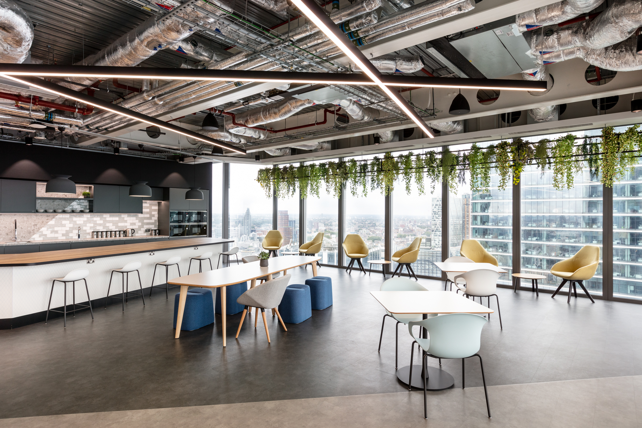 A spacious teapoint area with open ceiling designs and exposed ductwork with panoramic views at the Insurance and Risk Management Firm in Bishopsgate.