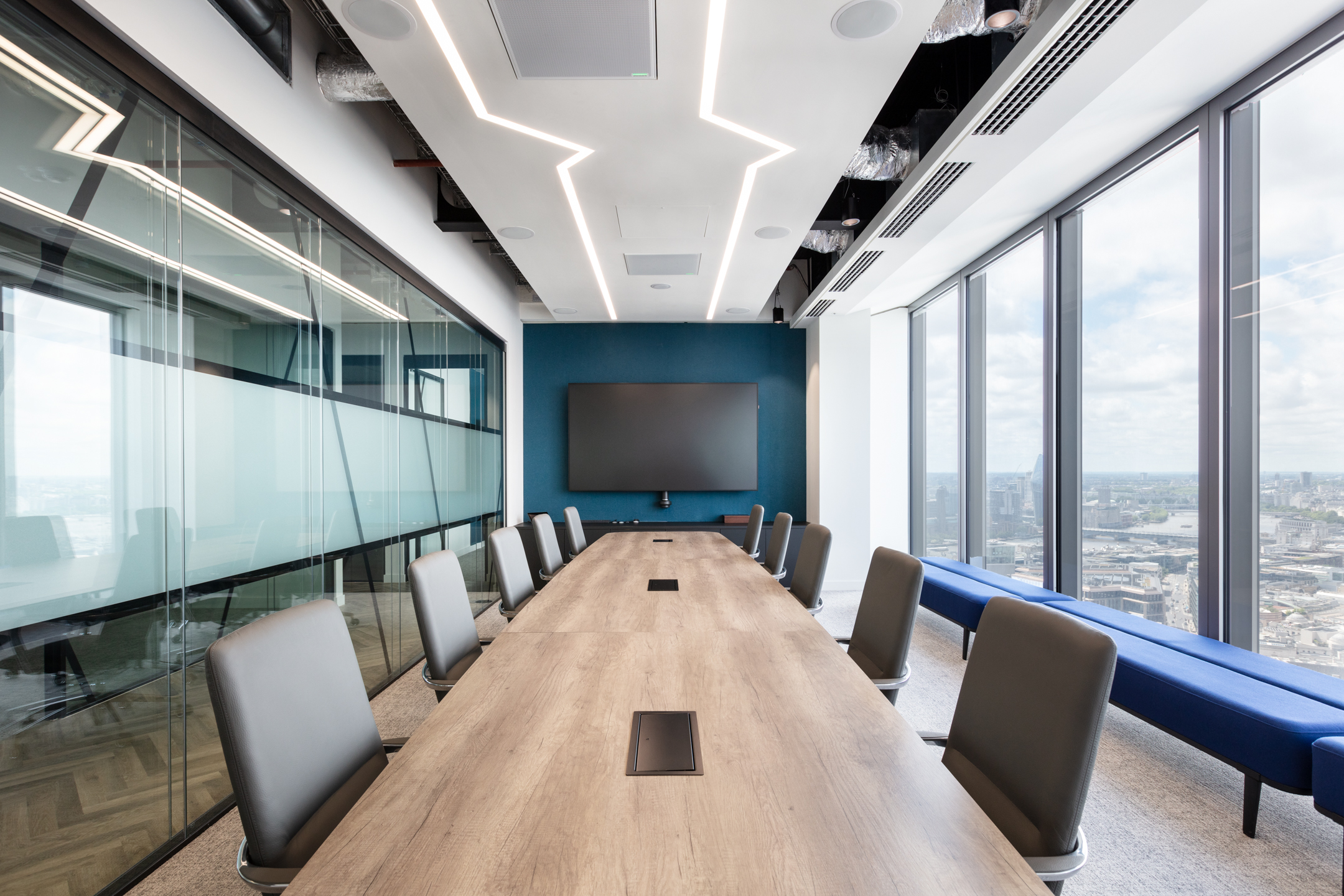 A high-tech boardroom with a long conference table, integrated technology, and expansive city views at the Insurance and Risk Management Firm in Bishopsgate.