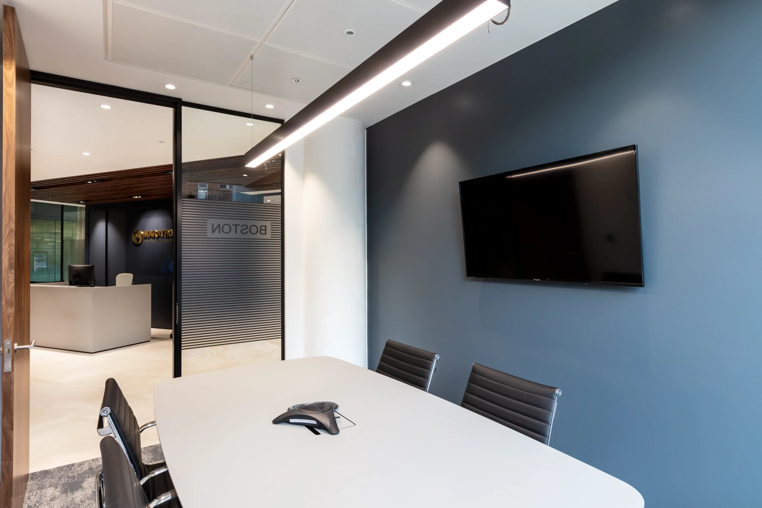 MCAP small meeting room designed by Modus, featuring a minimalist table and black leather chairs. The room provides a quiet and private space for small group discussions.