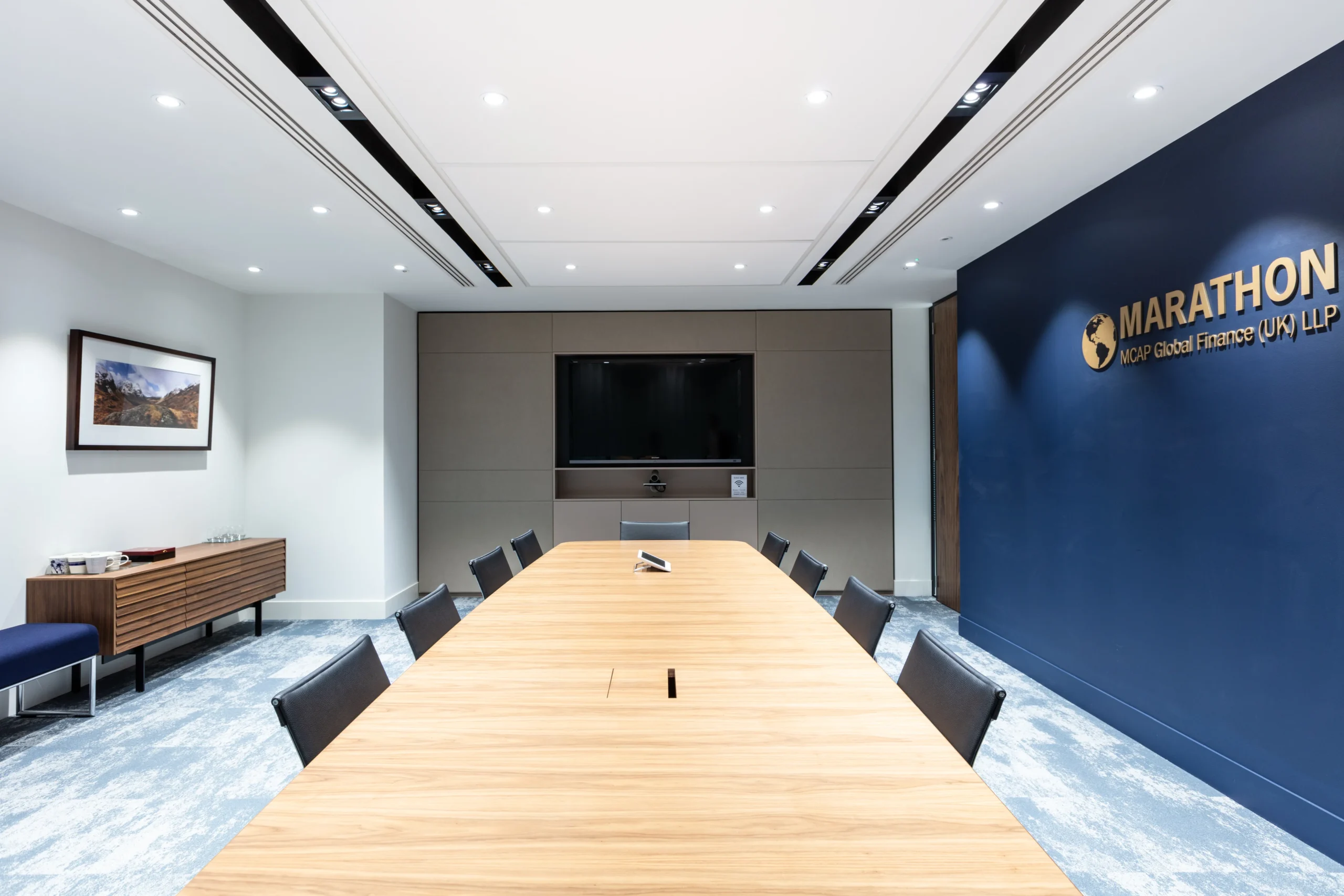 MCAP boardroom designed by Modus features a large wooden table and comfortable seating. The room provides a professional environment for client meetings and internal discussions.