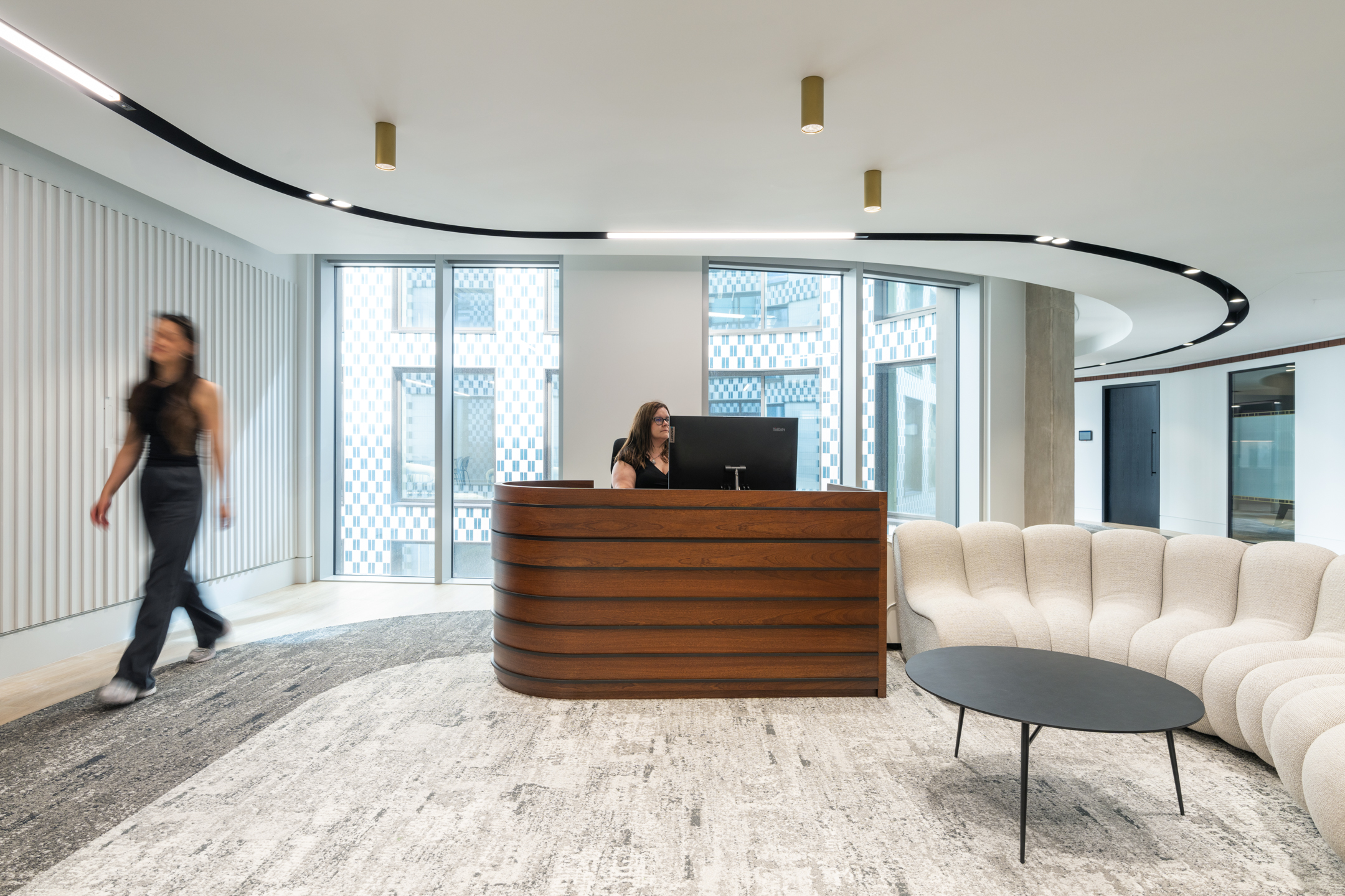 Seplat Energy reception area featuring a bespoke curved wooden desk, comfortable seating, and natural light.