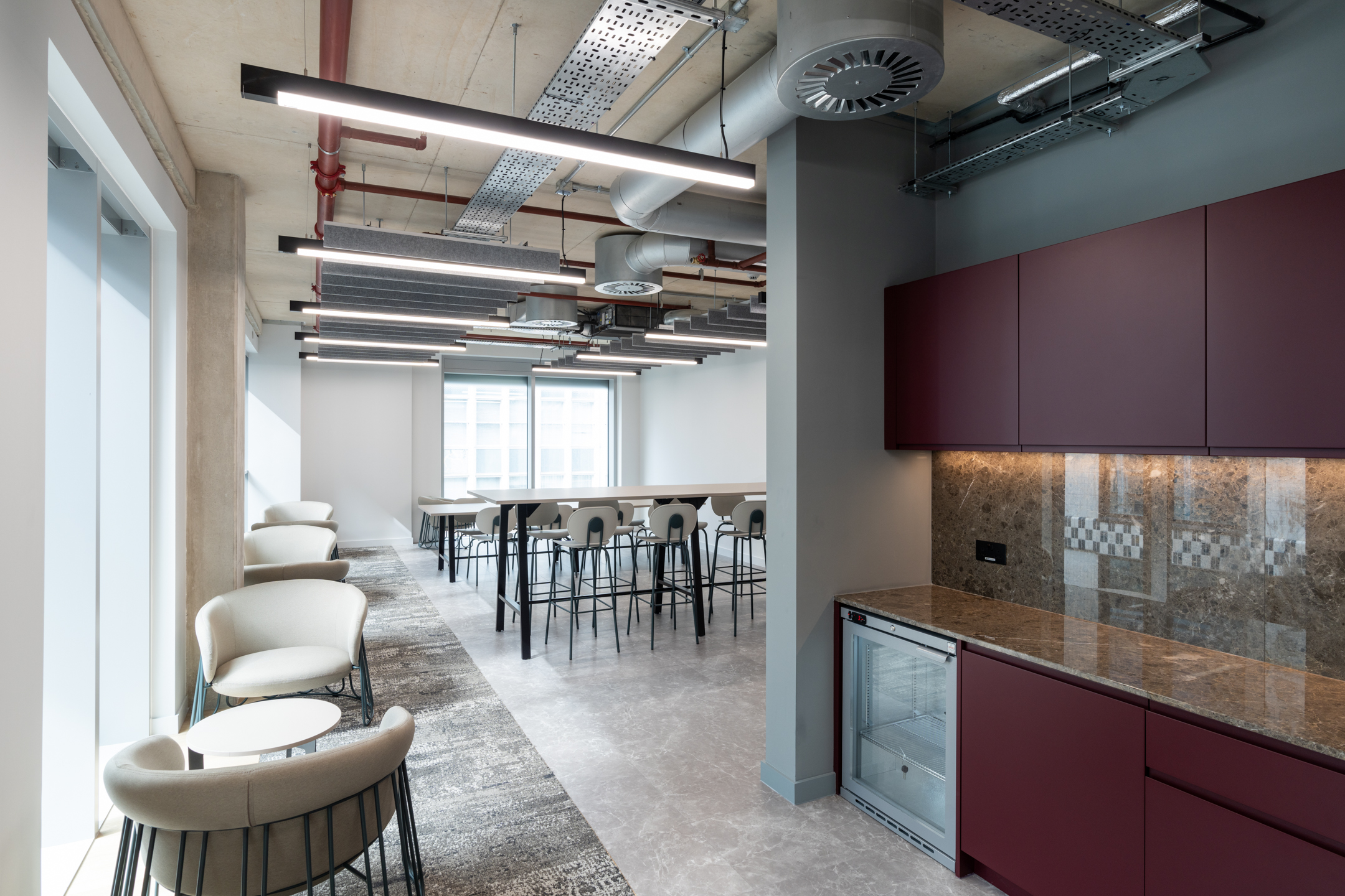 Seplat Energy office kitchenette and casual seating area with modern high stools and marble worktop.