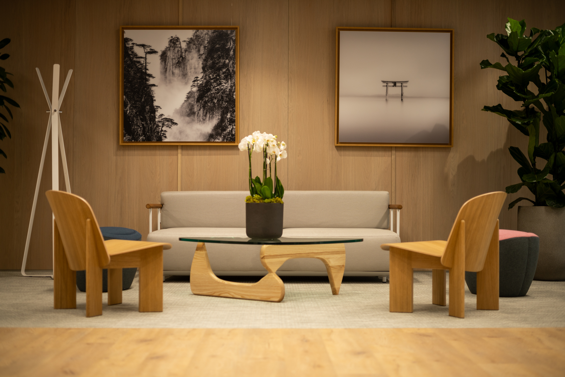 Shionogi reception waiting area with a sofa, wooden chairs, coffee table, and black-and-white wall art.