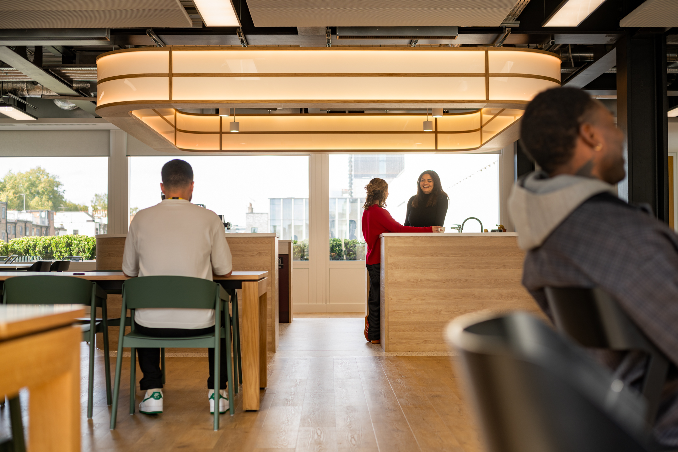 Home Page: Shionogi teapoint breakout view featuring team members laughing sparsely seated around the area