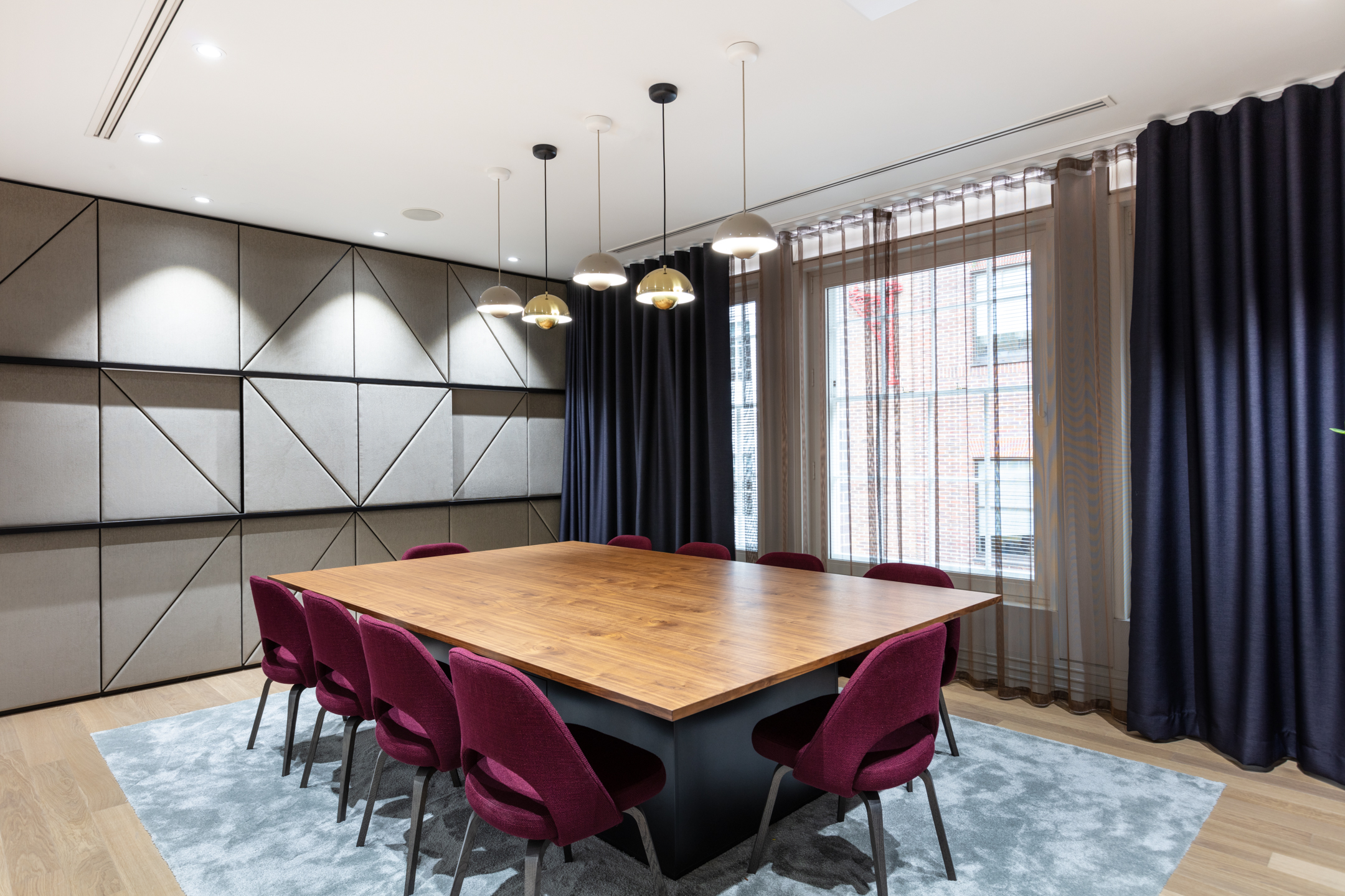 An elegant boardroom with modern lighting and rich wooden tables at Fujitsu Services Marylebone. Designed by Modus Workspace with an emphasis on functionality and style.