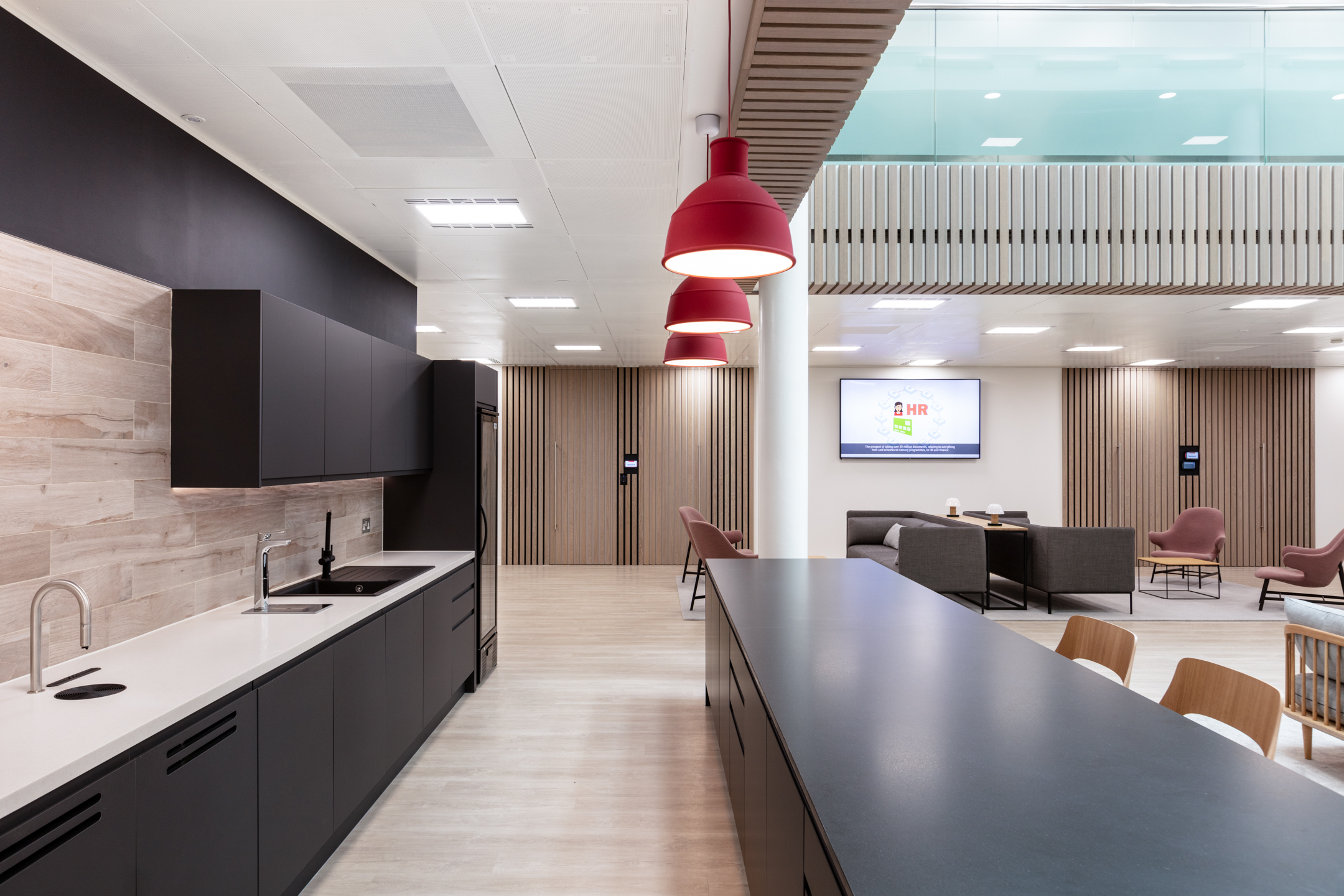 The sleek teapoint area with red pendant lighting and modern finishes at Fujitsu Services Marylebone, created by Modus Workspace.