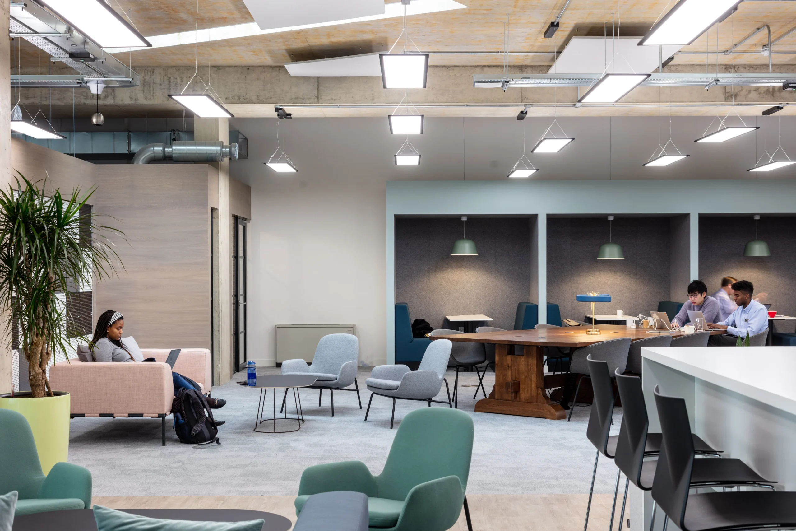 Collaborative breakout area at OSE featuring soft seating and acoustic booths to support focused work and innovation.