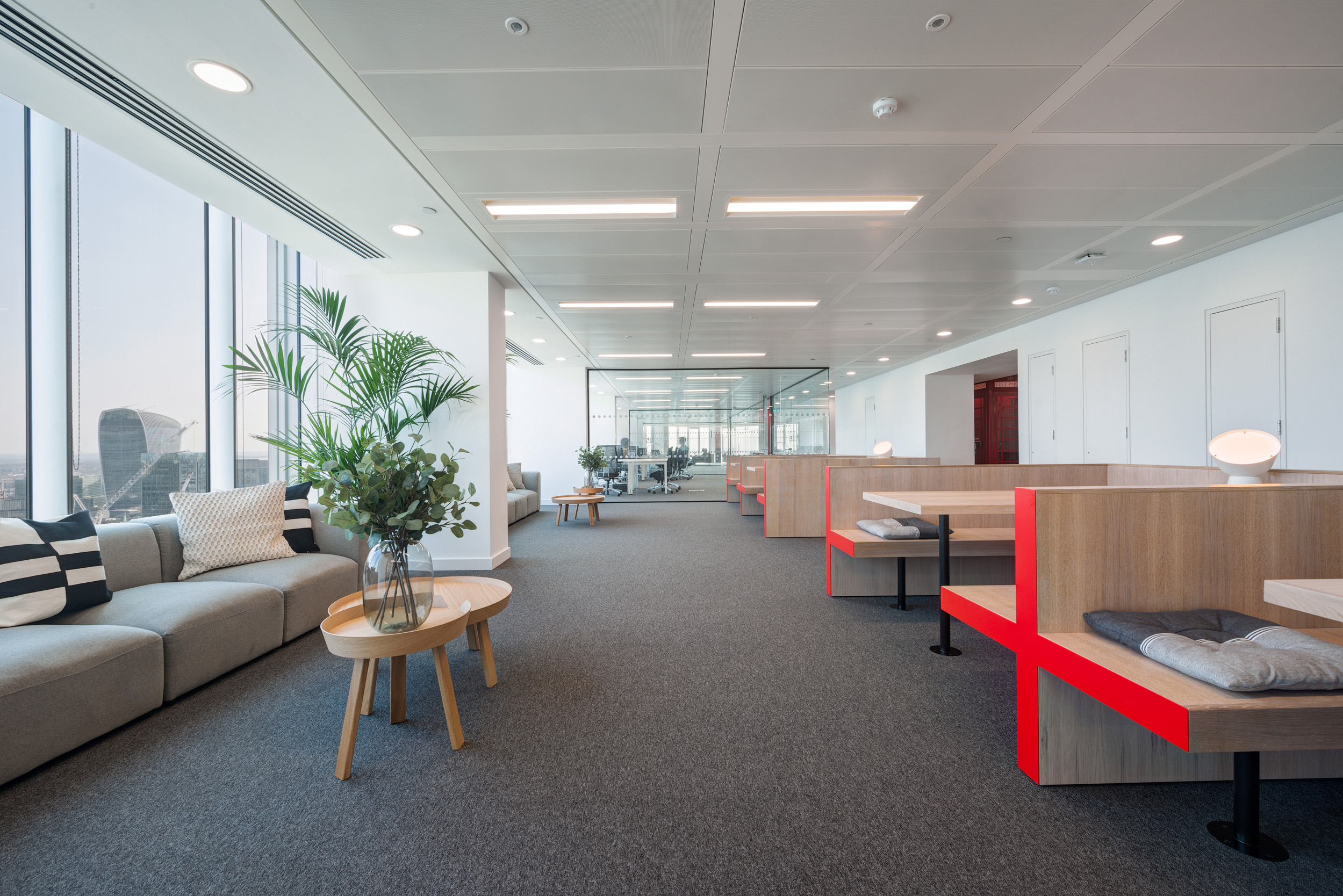 Open workspace in Primalbase's office, designed by Modus Workspace, featuring modern booths, large windows, and natural light for a productive work environment.