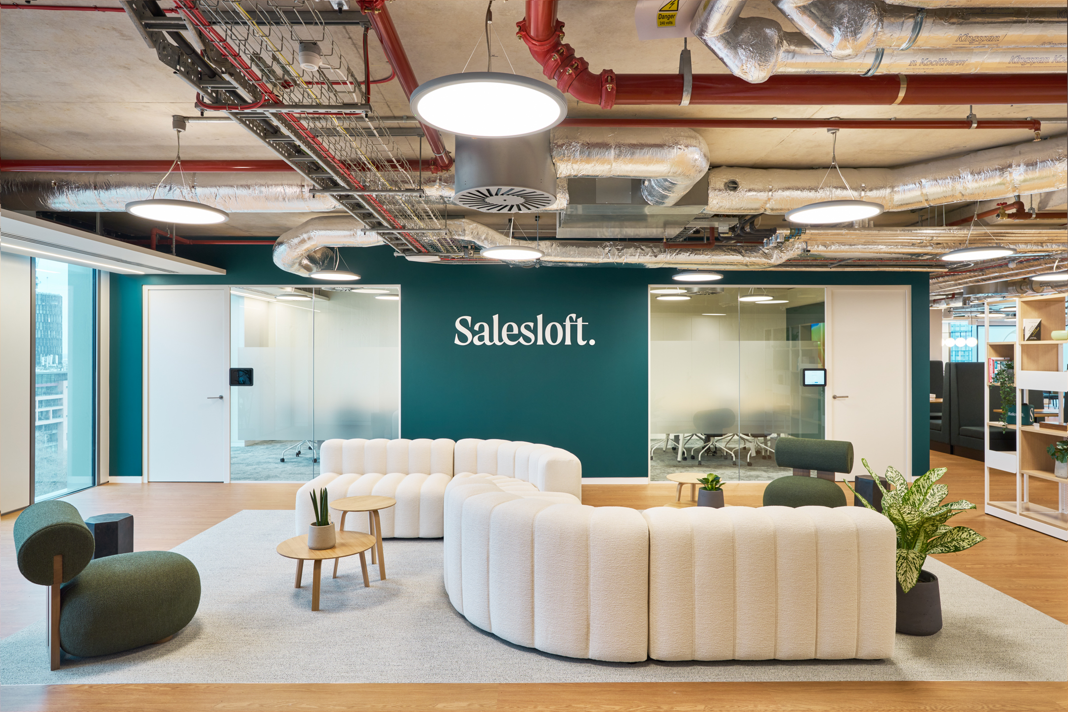Saleslost bespoke reception area, featuring a stylish curved sofa and the company logo, welcoming visitors to a modern, brand-focused environment.
