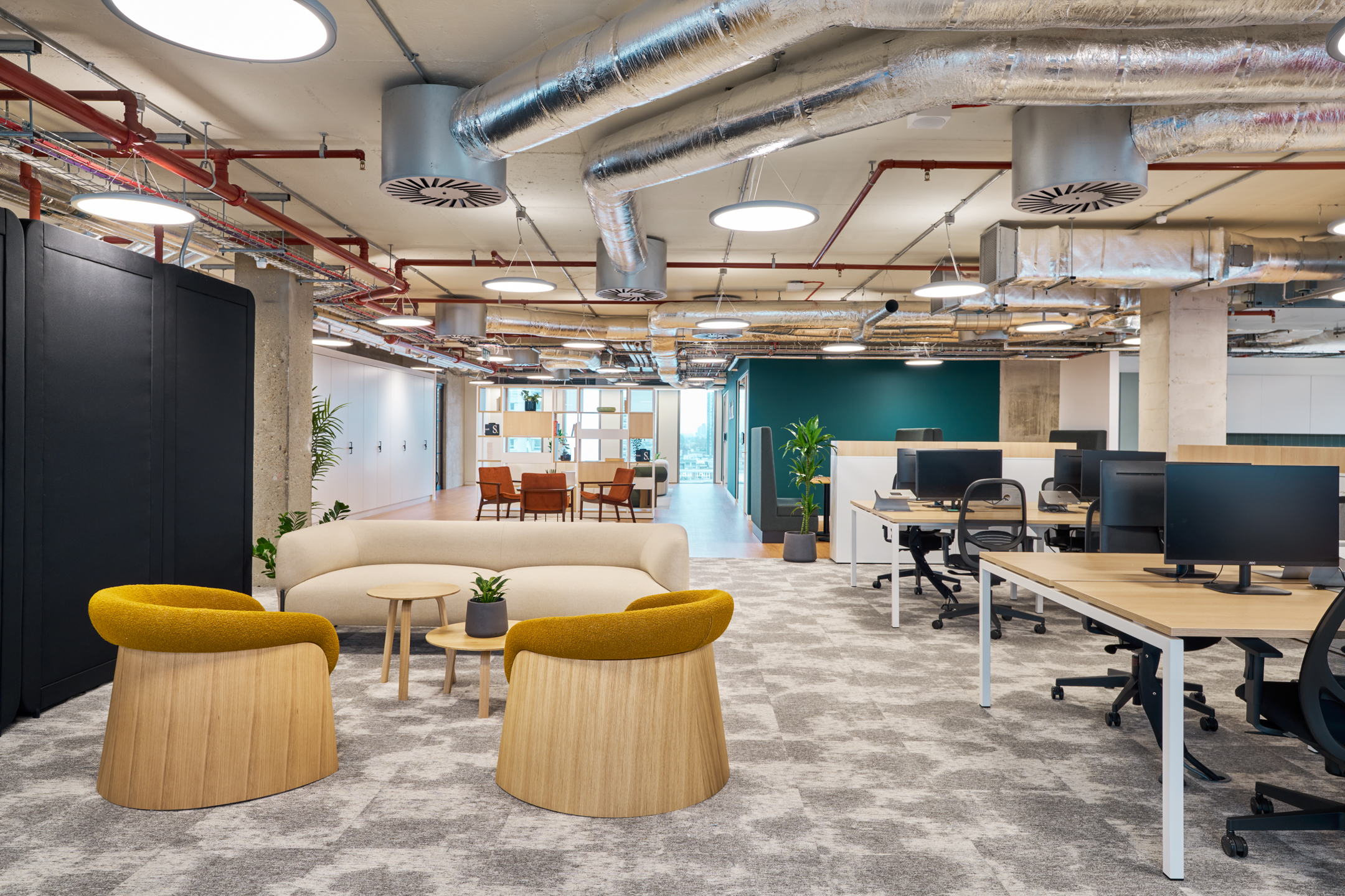 Salesloft open-plan workspace in Salesloft’s London office, showcasing collaborative areas with bright, contemporary design and exposed industrial elements.
