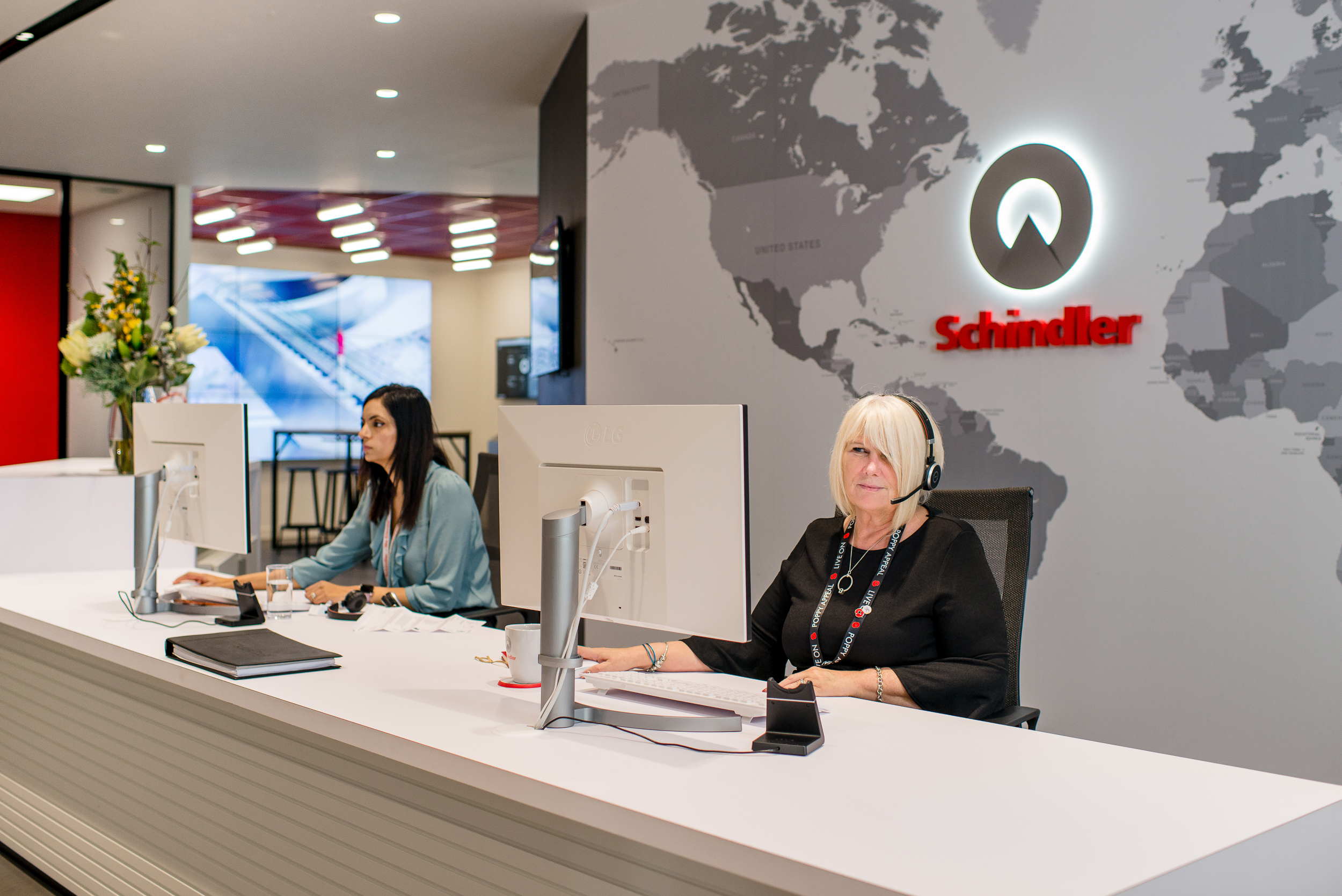 Reception area at Schindler Group's UK headquarters, showcasing the company's global reach with a world map and logo on the feature wall