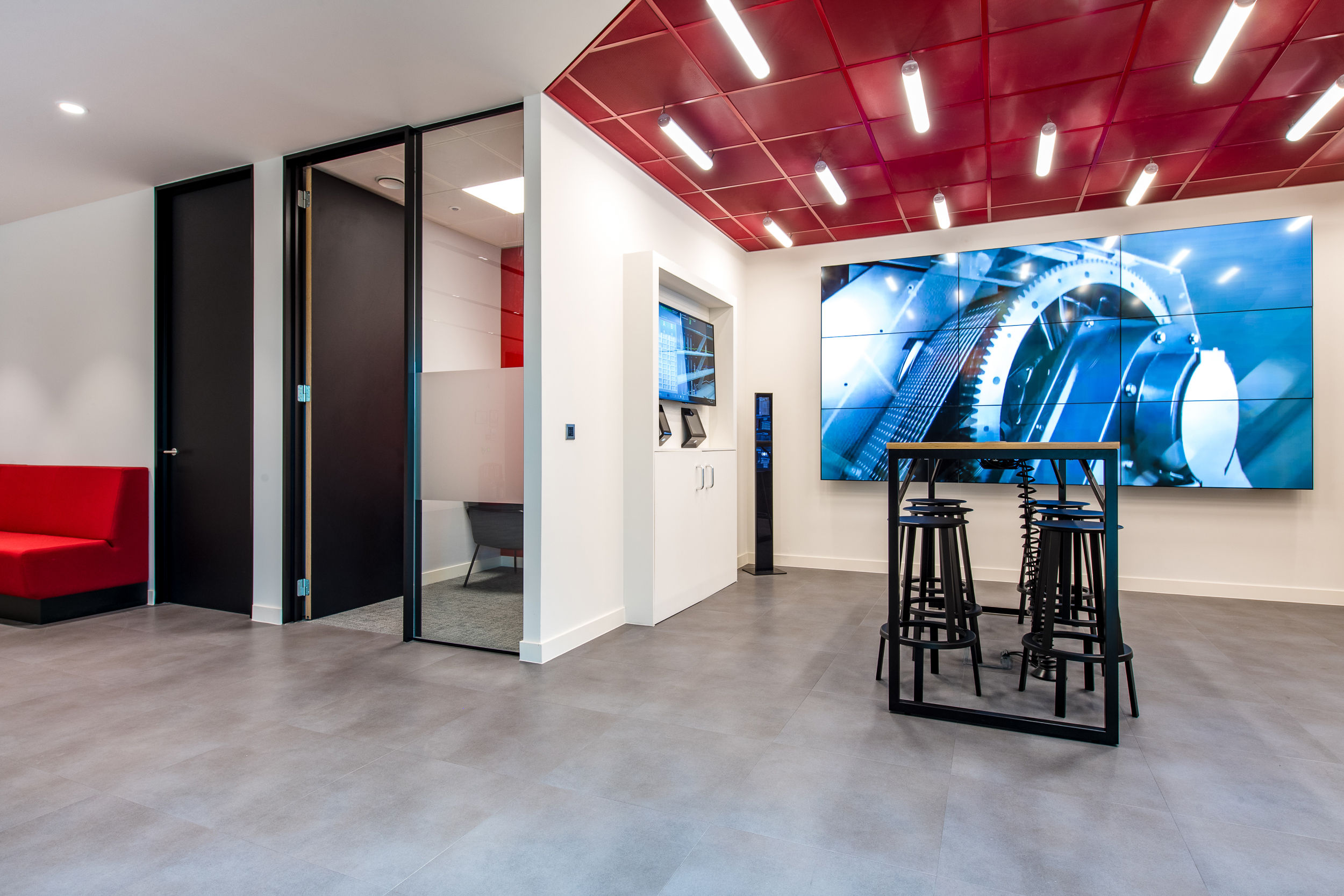 Bright and modern collaboration space at Schindler Group's office, complete with interactive digital displays and seating areas