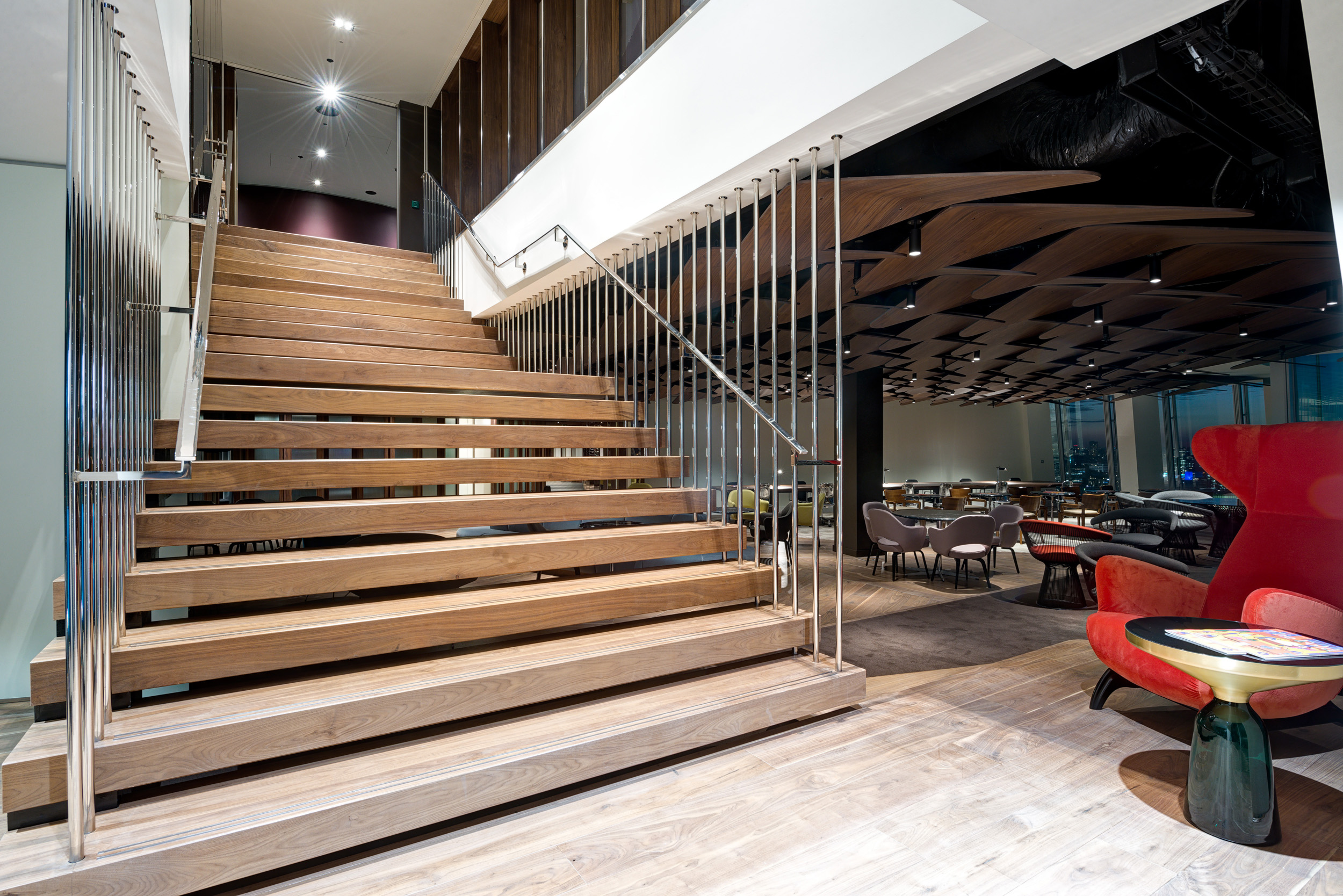 Floating timber staircase connecting floors at The Office Group's workspace in The Shard, creating a seamless transition between levels.