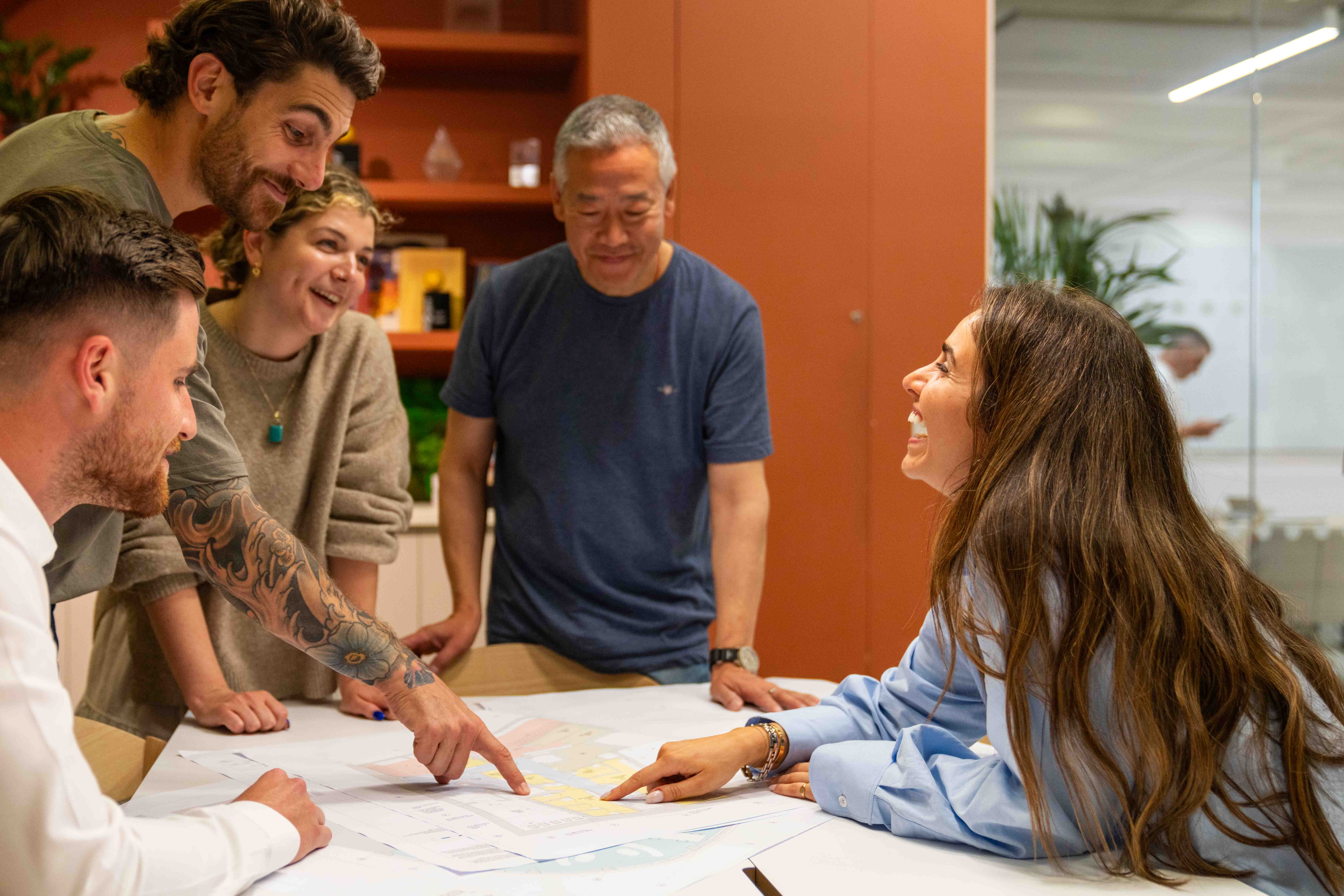 Modus staff collaborating on a project plan, reflecting teamwork and strategic planning, driving the company's recognition in the Sunday Times PwC Top Track 250.