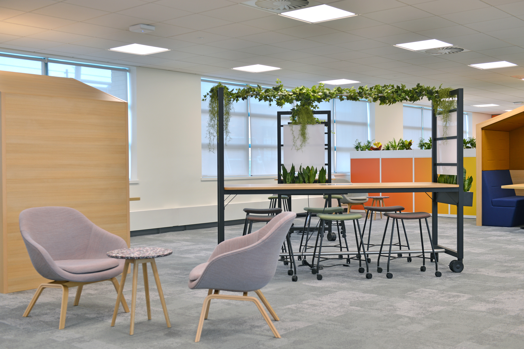 Warrington open area desking with seating and greenery at Fujitsu Services Warrington, designed by Modus Workspace, fostering a relaxed atmosphere for team discussions and informal meetings.