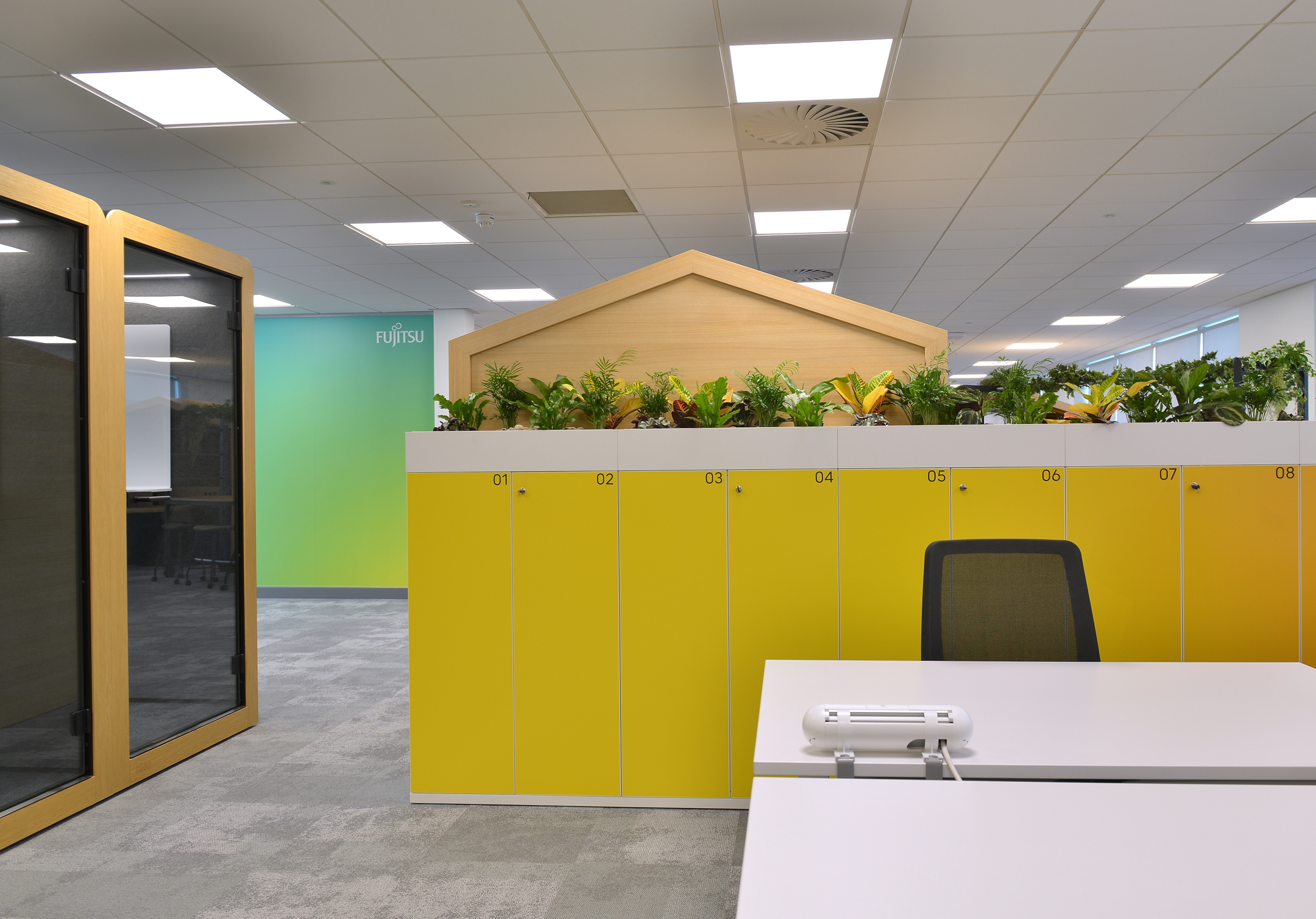 Warrington modern workspace at Fujitsu Services Warrington with colourful desking, plotted plants and private phone booths designed by Modus Workspace.