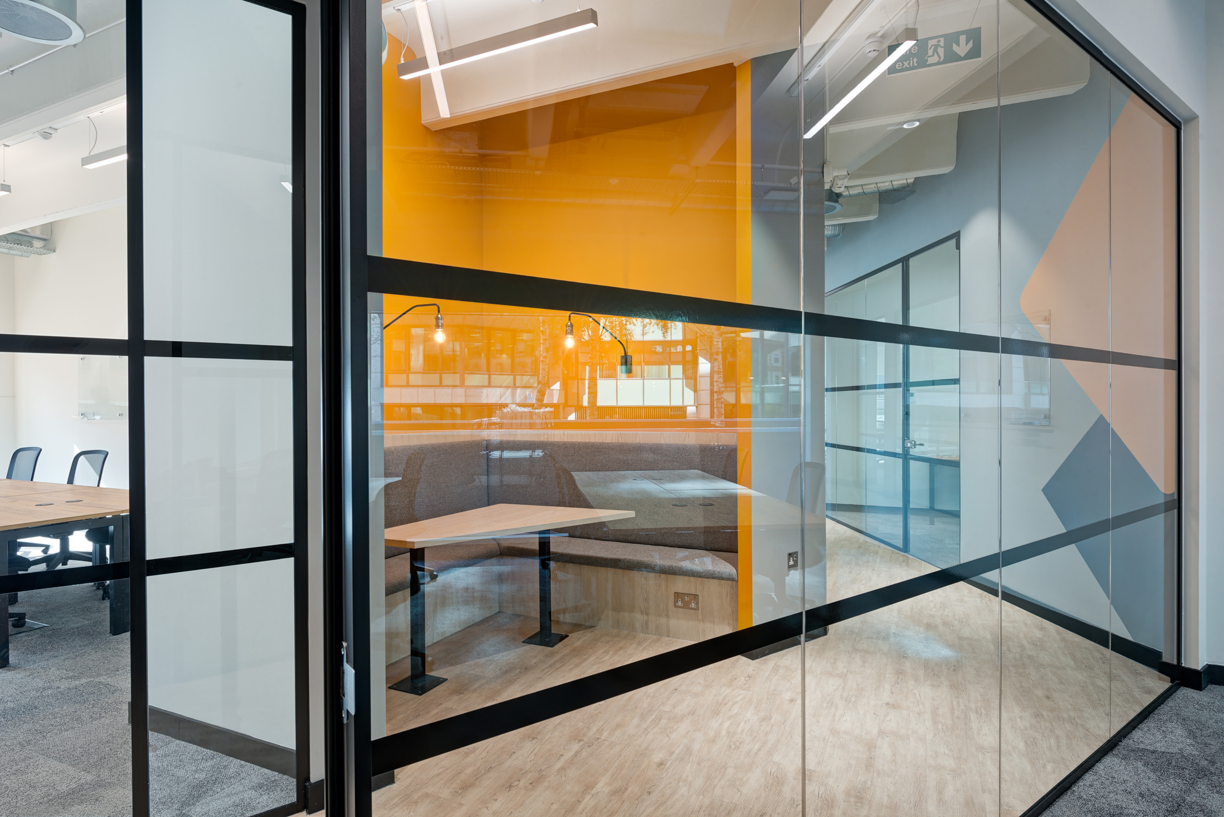Colourful meeting booths with glass partitions in the Worklife Reading office, designed by Modus Workspace.