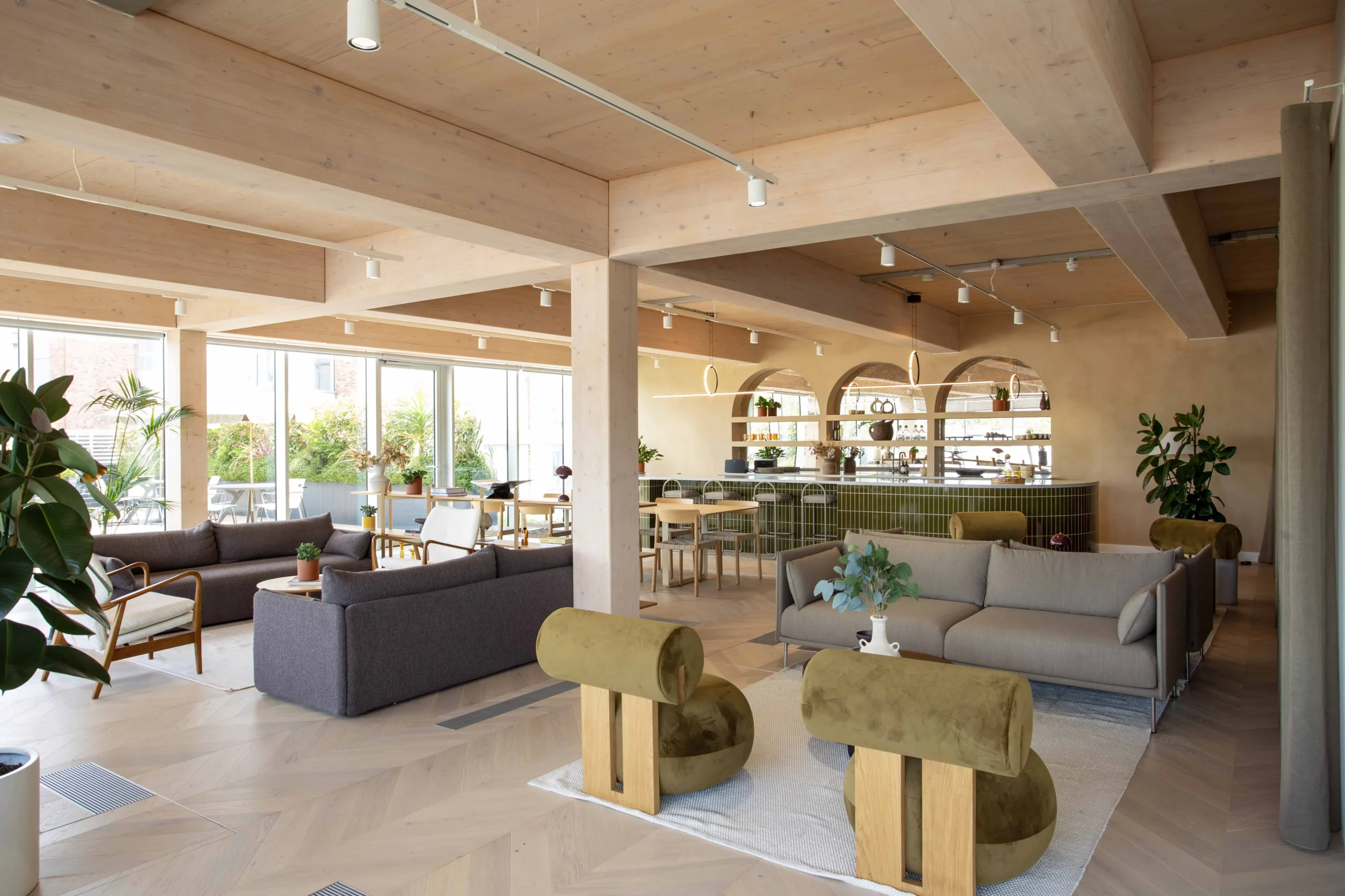Techspace teapoint wide view showcasing green and grey seating areas, a pillar central to the room and a green tiled teapoint bar.