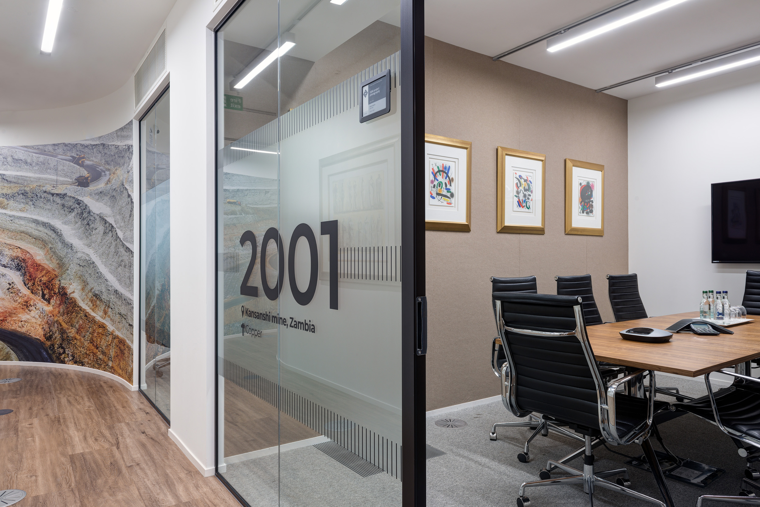 First Quantum Minerals private meeting room with bespoke partition designs, and a 8 person table and screen.
