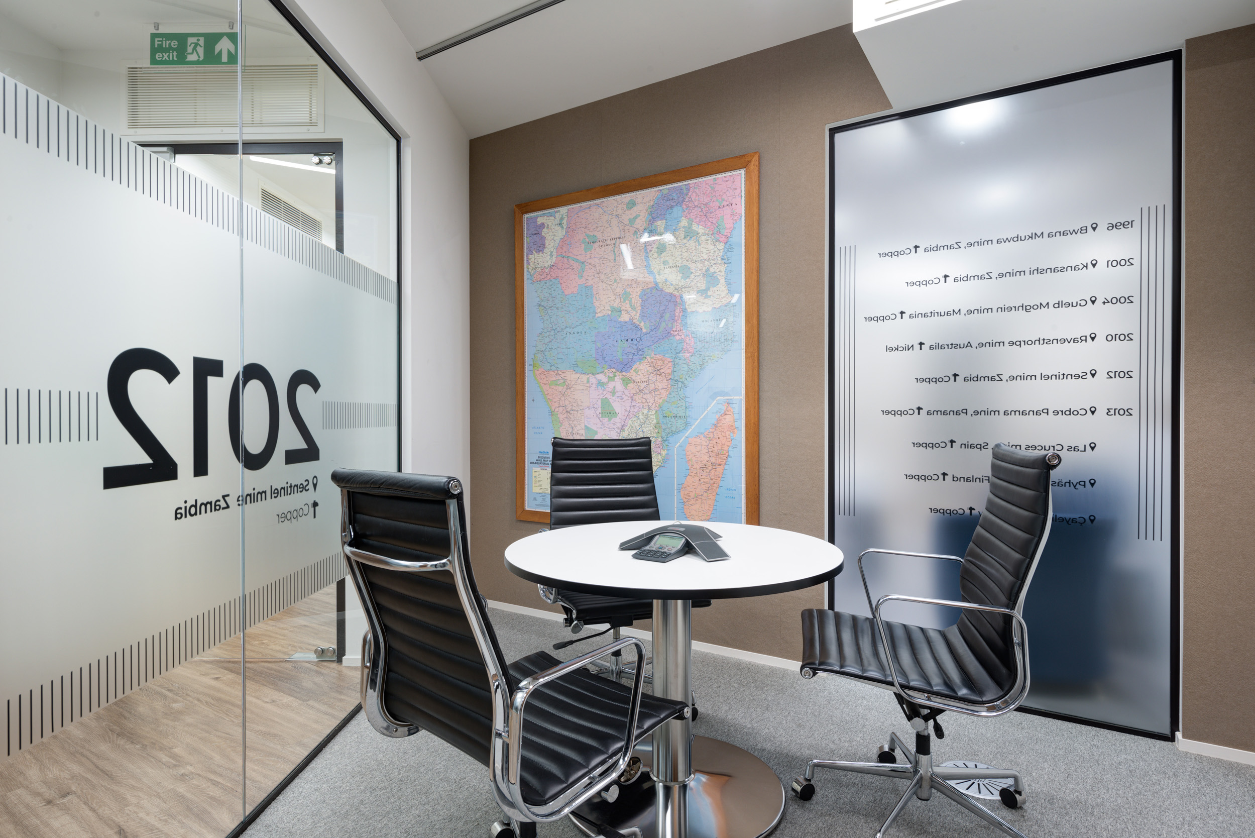 First Quantum Minerals bespoke private meeting room with a world map, frosted glass petitions and sleek furnishing.