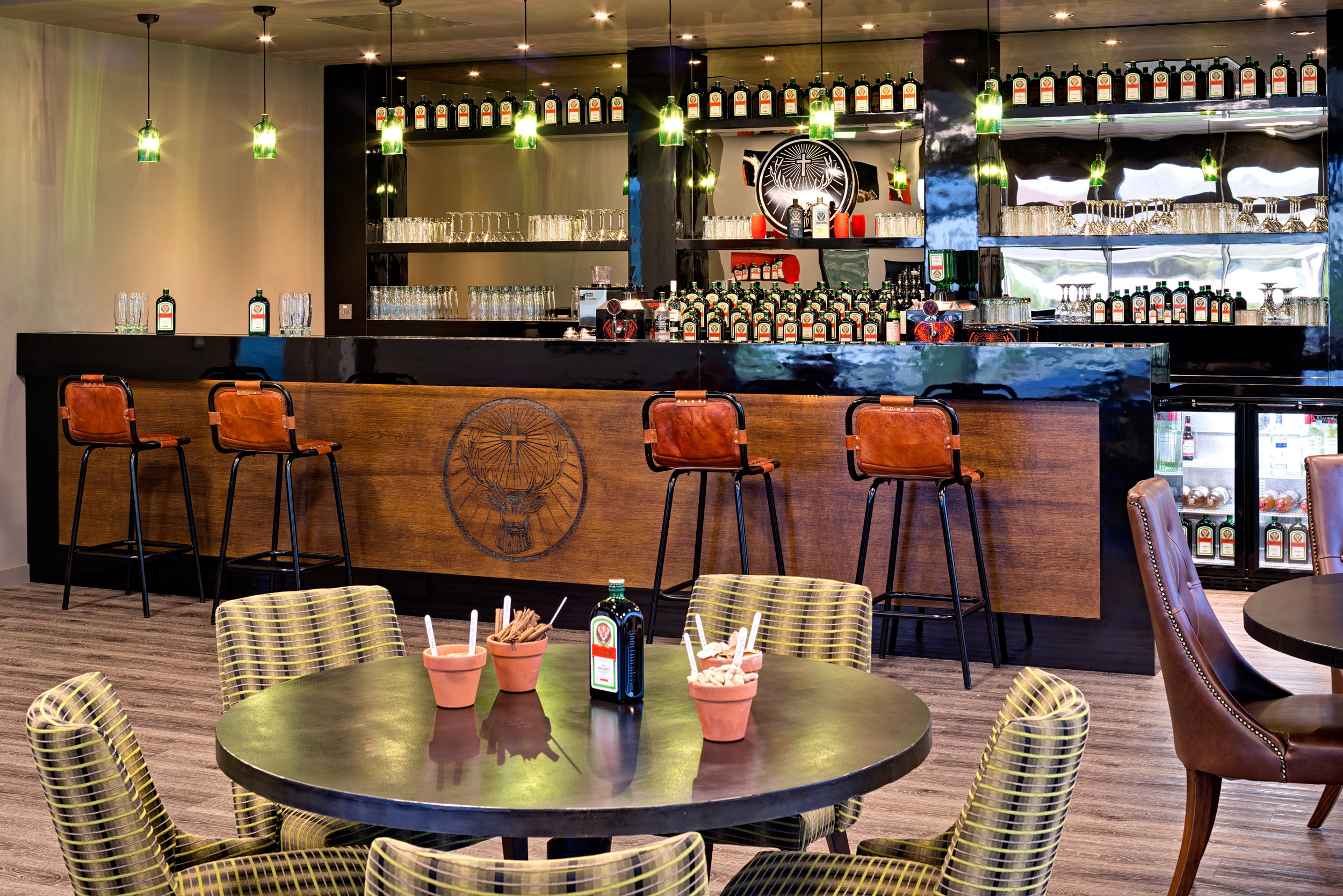 Jägermeister Seating Area and Bar rustic wood bar at Jägermeister featuring branded bottles, high seats and a seating area