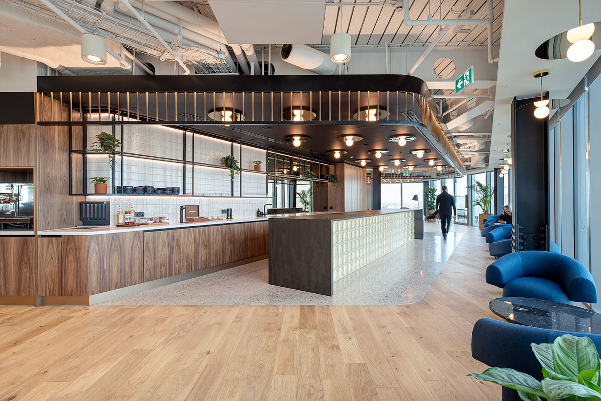 International Technology and Data Firm teapoint, with hanging bespoke lights, blue soft chairs, and plotted plants