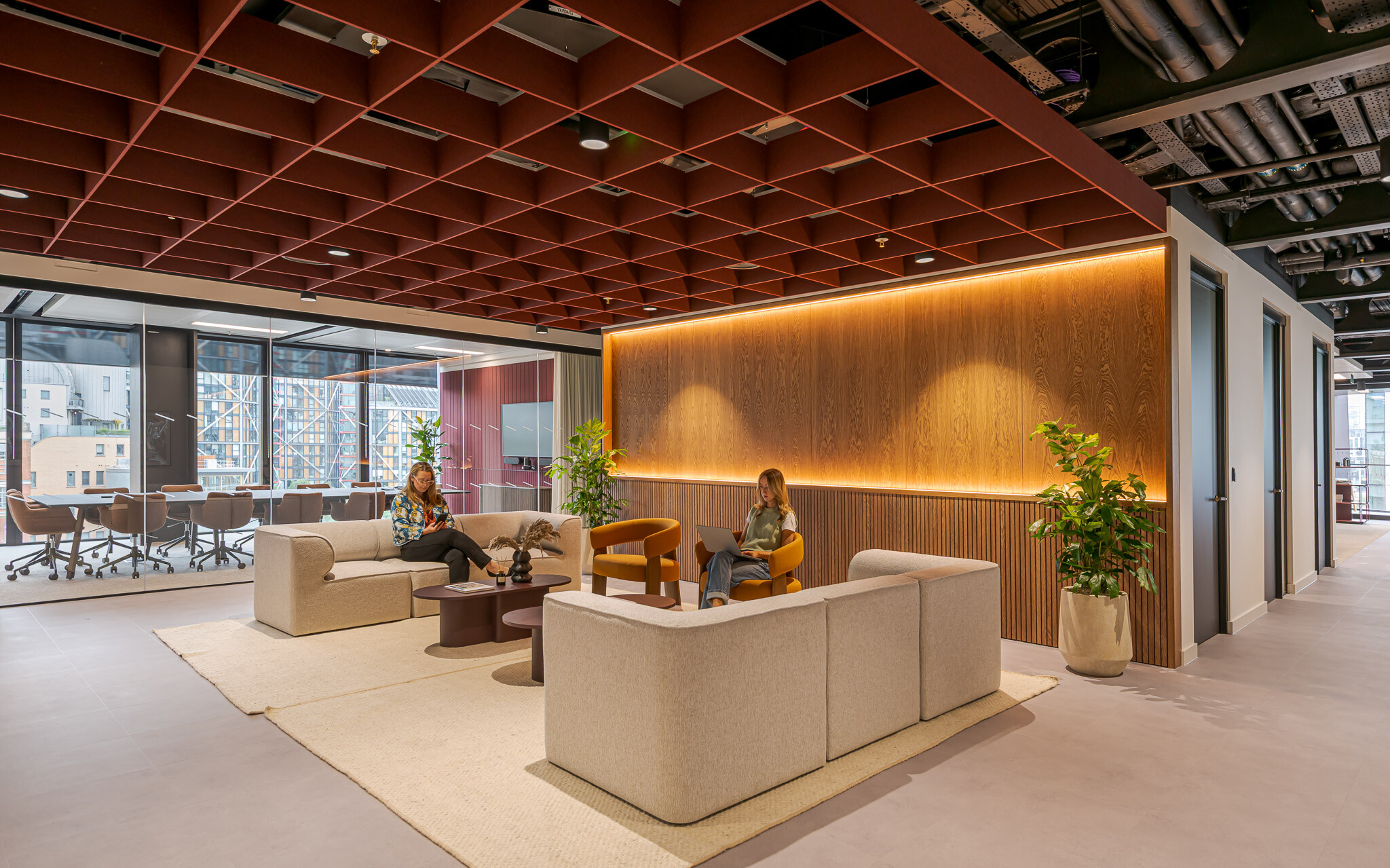 Tenant-Ready™ reception at Arbor Level 4, designed by Modus, featuring neutral-toned modular seating, warm timber panelling with integrated lighting, and a view into the glazed meeting room with city-facing windows.