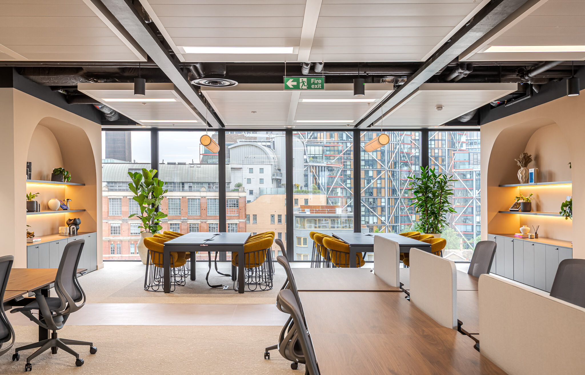Open-plan workspace at Arbor Level 4 Tenant-Ready™ featuring shared desks, curved alcove shelving, biophilic accents and expansive glazing with city views across London.