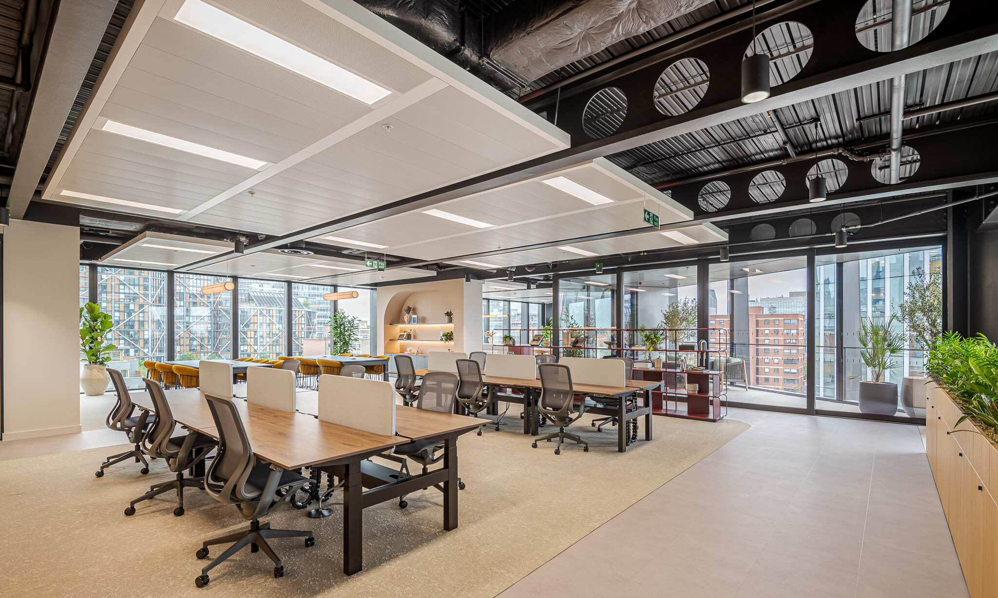 Full view of the Arbor Level 4 Tenant-Ready™ workspace by Modus, featuring desking zones, shared tables, open shelving, and floor-to-ceiling glazing leading to a balcony with potted greenery.