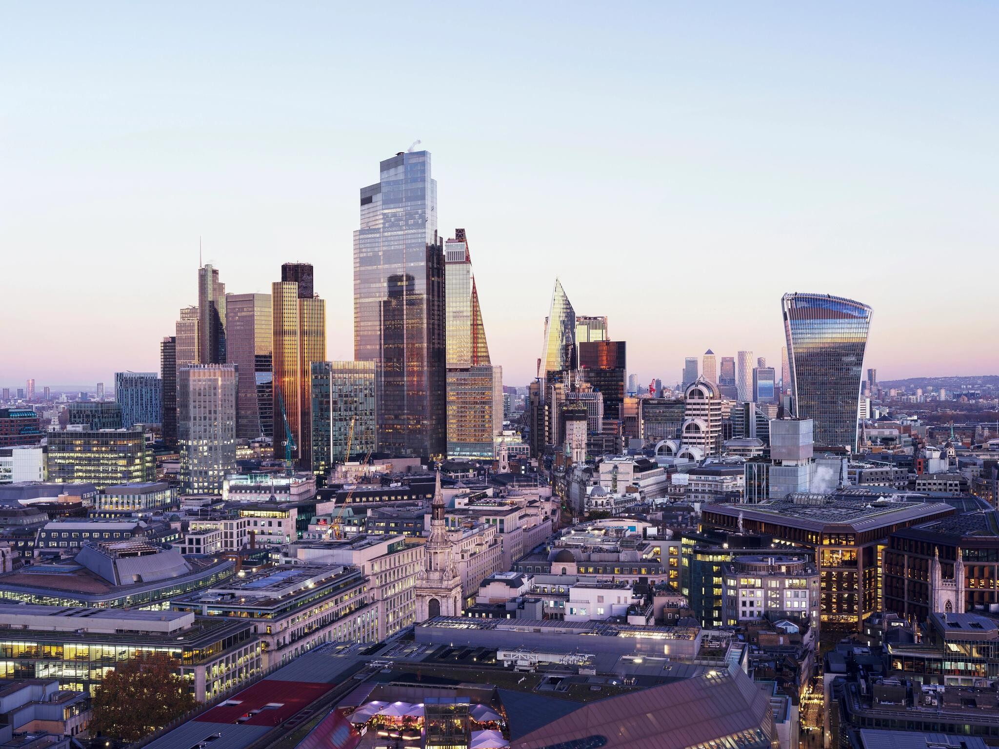 Panoramic view of London's financial district skyline at dusk, featuring major office landmarks such as The Leadenhall Building, 22 Bishopsgate, and the Walkie Talkie, reflecting Q2 market activity.