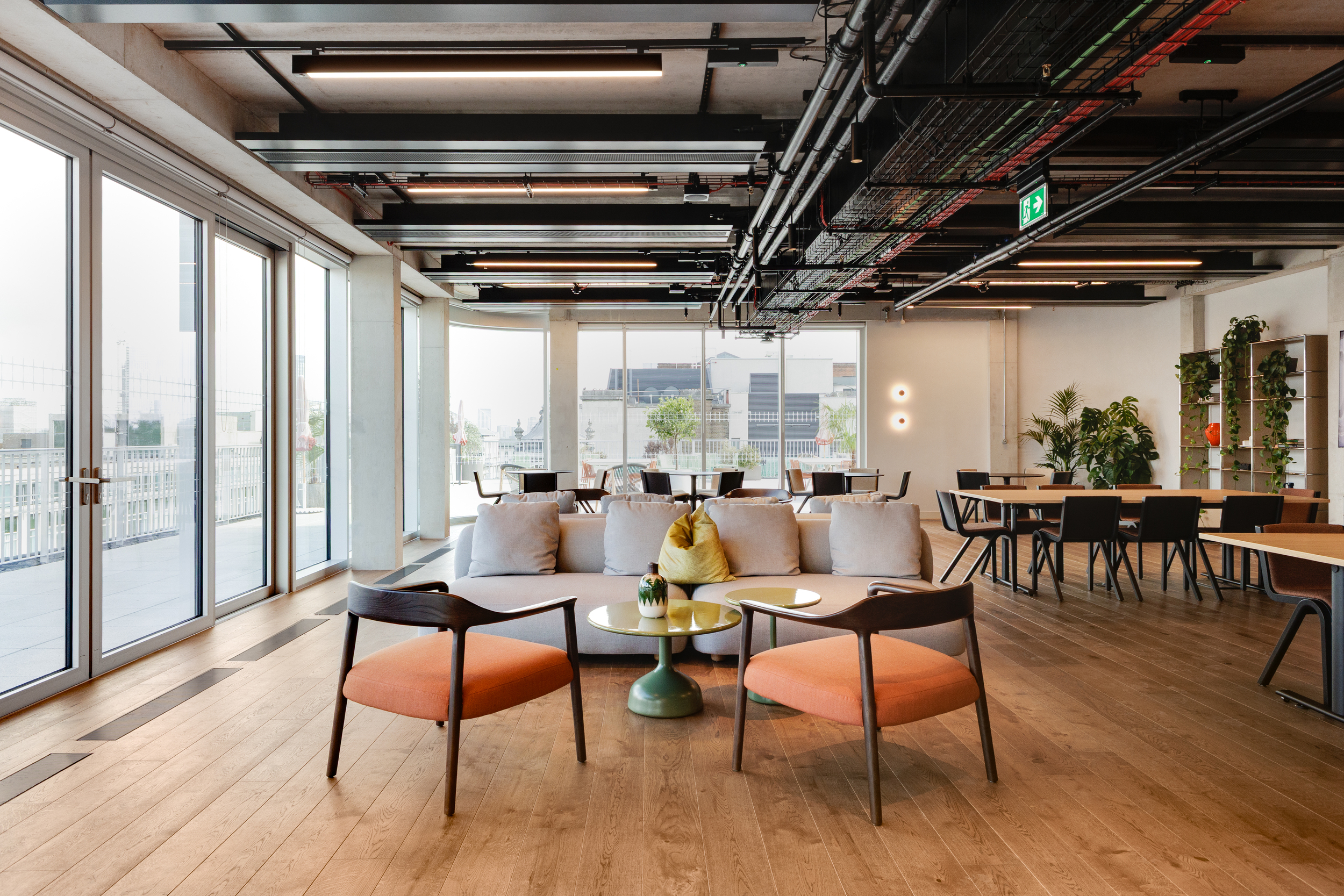 Modus designed the Space House Clubhouse interior as a flexible social space with warm timber flooring, soft seating, and large windows leading out to the terrace.
